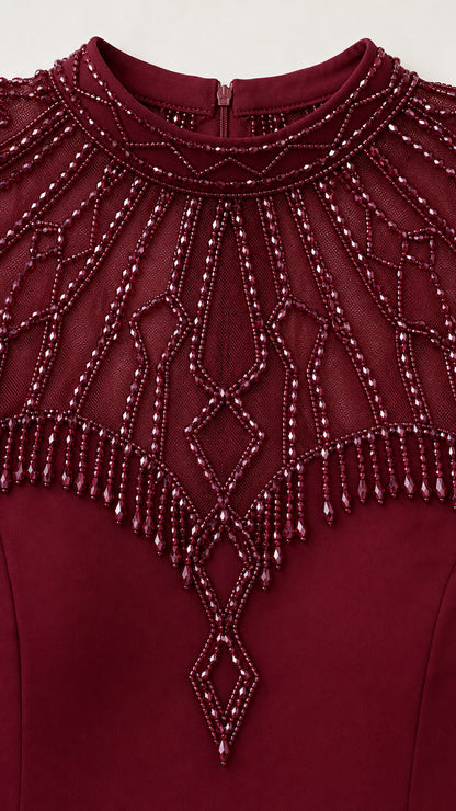 Close-up detail of ornate beadwork and fringe on neckline and cap sleeves