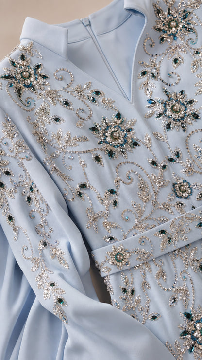 Close-up detail of crystal beading and notched neckline on light blue gown