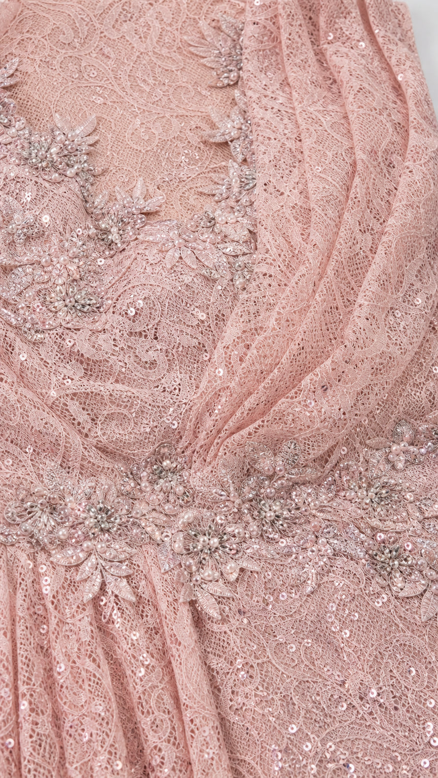 Close-up detail of blush pink sequin lace, floral appliqué, and beaded waist embellishment