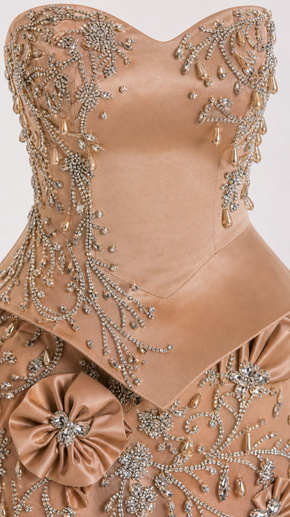 Close-up detail of beaded bodice, satin peplum, and 3D floral appliqué