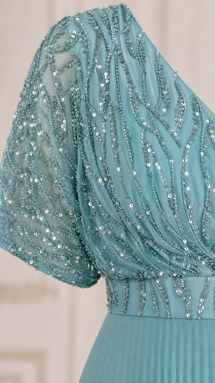 Close-up detail of teal blue sequin embroidery and flutter sleeve