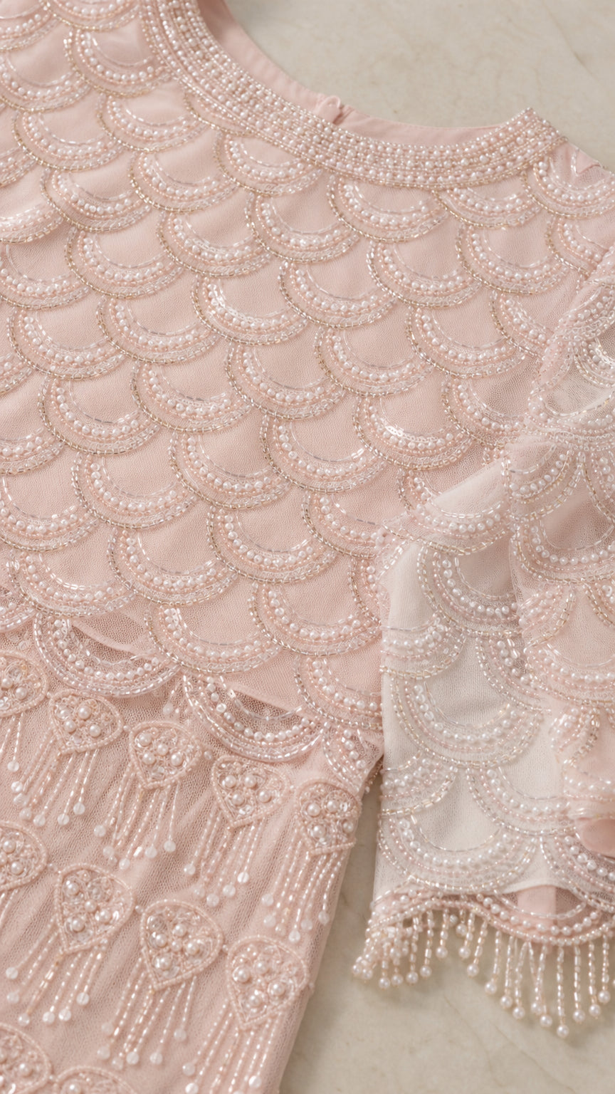 Close up detail of intricate pearl beading and scalloped trim on evening gown