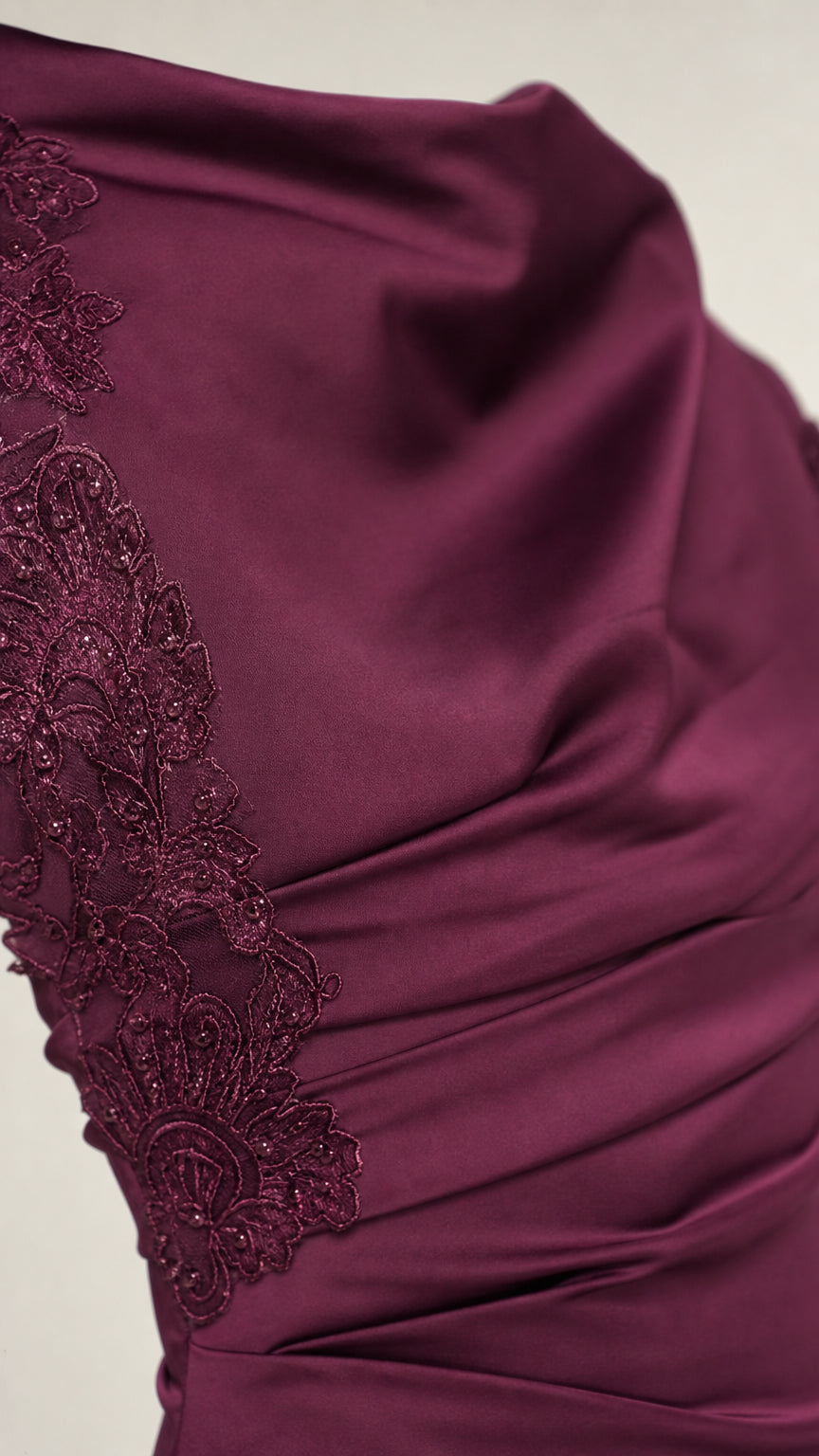 Close-up detail of plum dress ruched bodice and delicate lace embroidery
