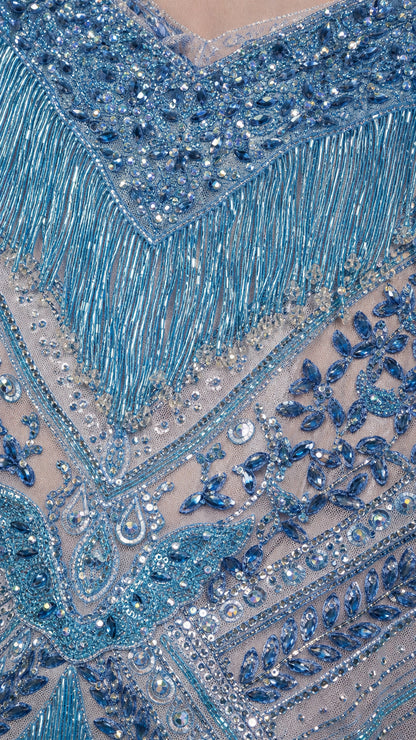 Close-up detail of intricate beadwork, blue sequins, crystals, and fringe trim
