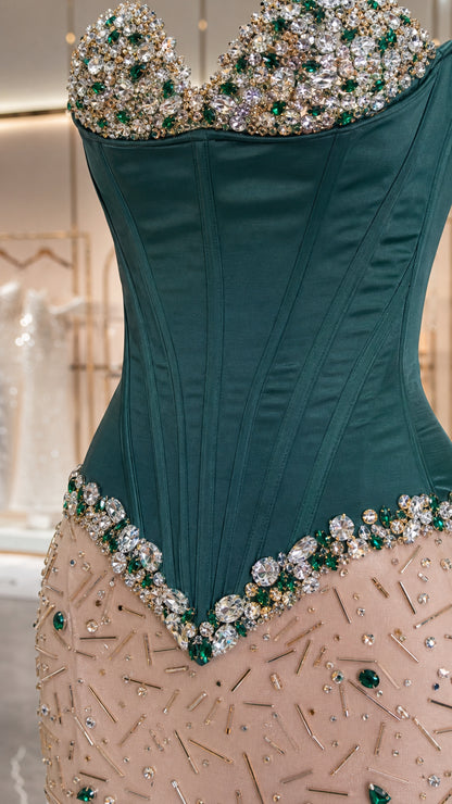 Close-up detail of emerald green corset bodice with crystal bust and waist embellishments