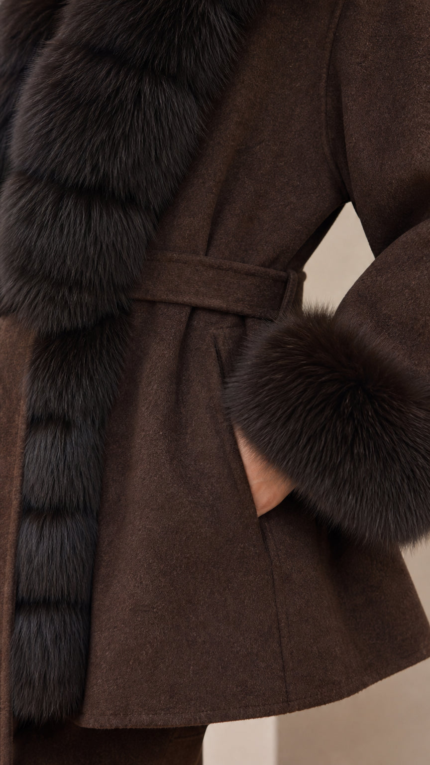 Close-up detail of chocolate brown coat fabric, side pocket, and plush fur trim