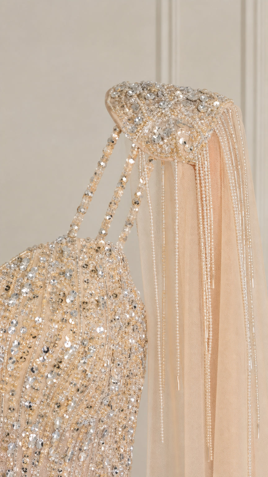 Close-up detail of crystal beading and fringe epaulettes on dress shoulder