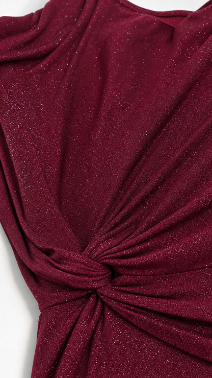 Close-up detail of burgundy glitter fabric with ruched knot waist construction