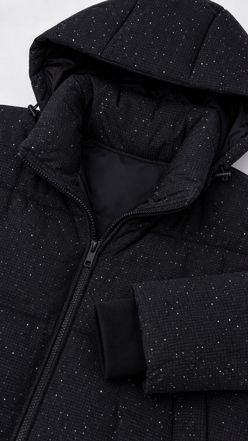 Close-up detail of black sparkly fabric texture, hood, zipper, and storm cuff