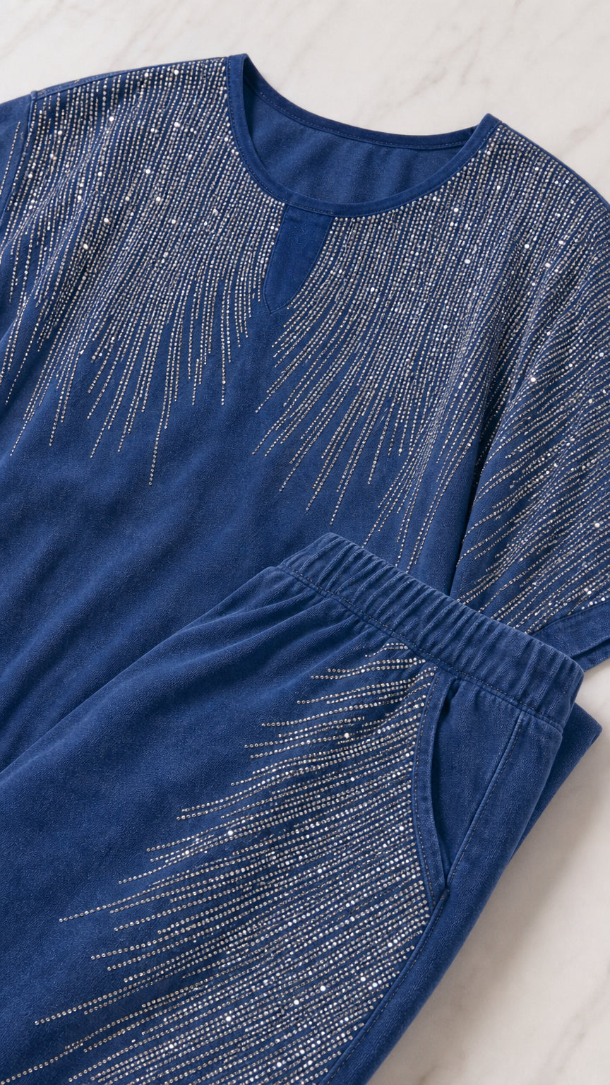 Close-up flat lay of blue knit top with sparkling rhinestone neckline and matching elastic pocket detail