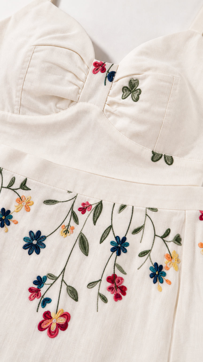 Close-up detail of fabric, sweetheart neckline, and colorful floral embroidery