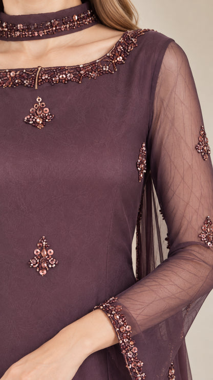Close-up detail of beaded neckline and sheer sleeve cuff on plum tunic