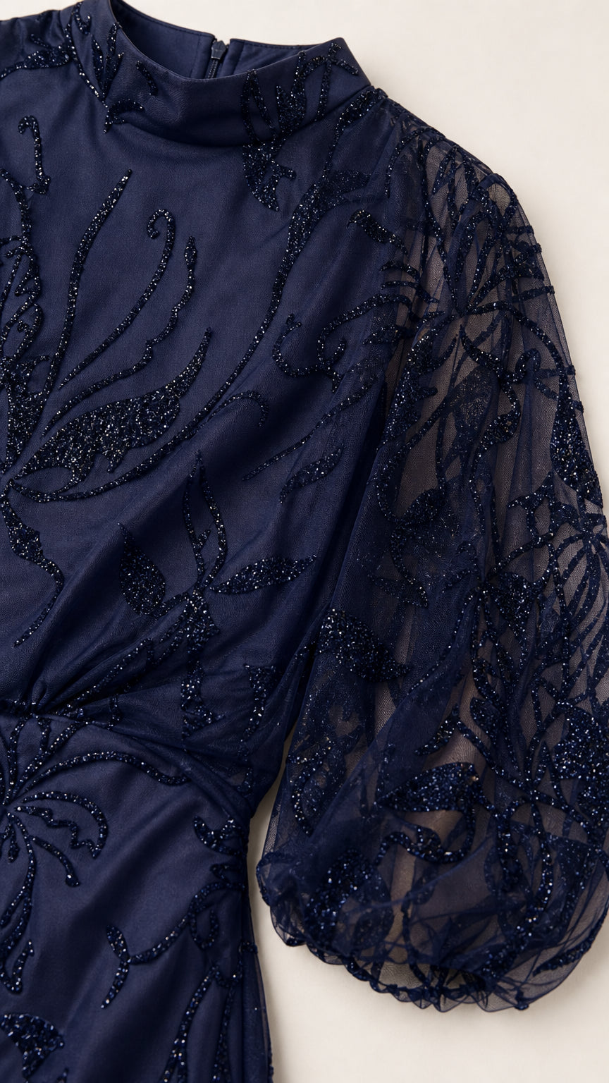 Close-up of navy blue beaded neckline and sheer balloon sleeve