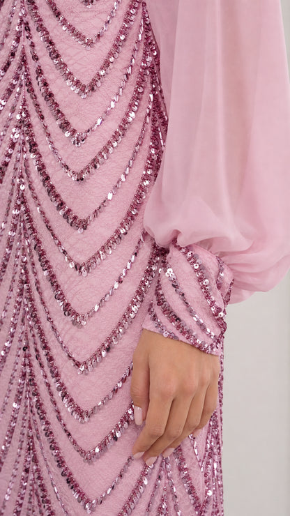 Close-up detail of shimmering chevron sequin pattern and sheer cuff on pink evening dress