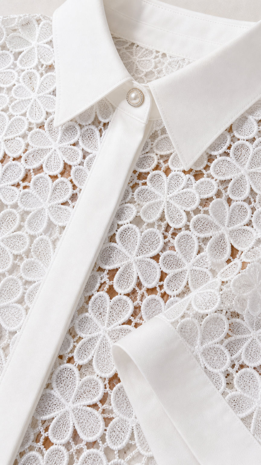 Close-up detail of white crochet floral lace and collared button front