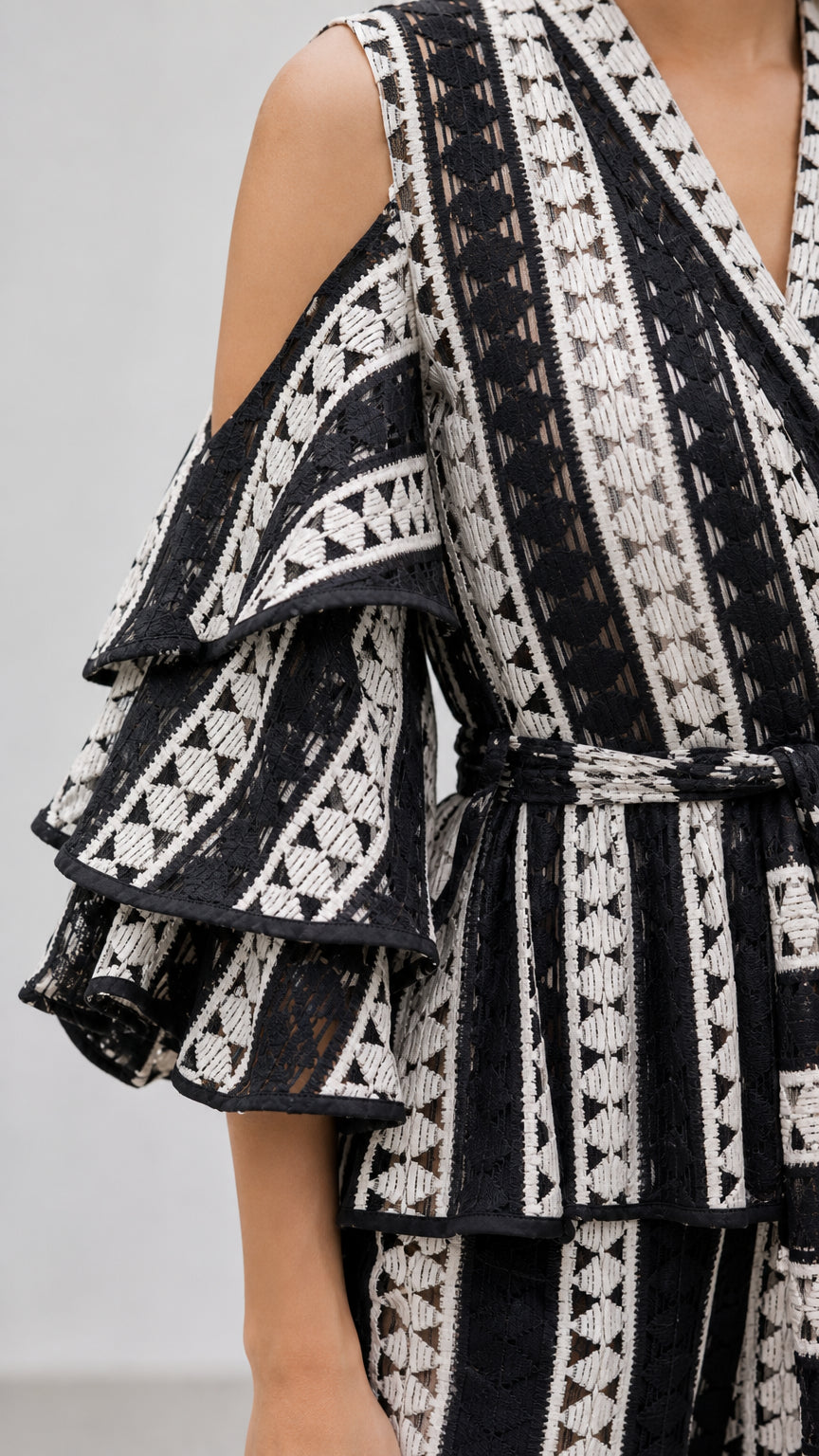 Close-up detail of tiered cold-shoulder flutter sleeve and geometric patterned fabric