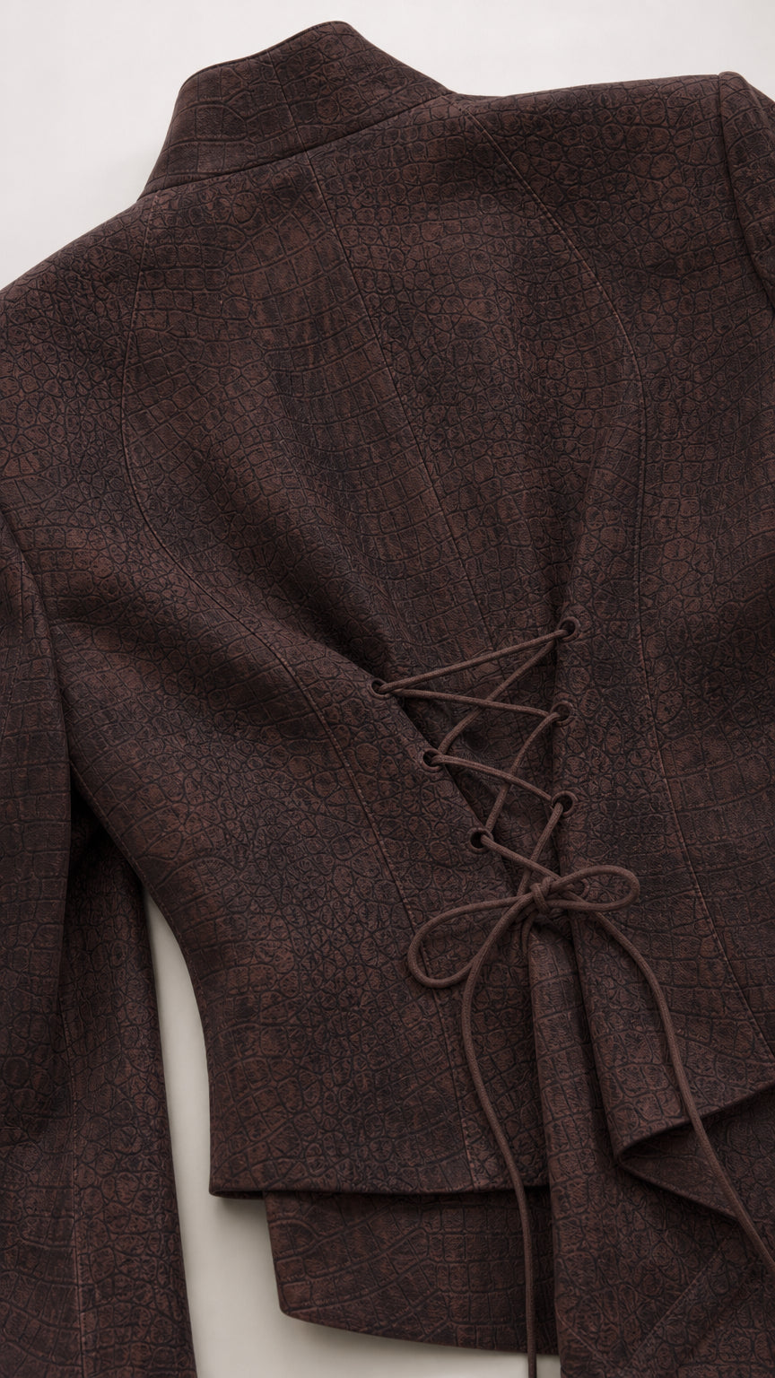 Close-up detail of textured woven fabric and corset lace-up tie on the blazer back