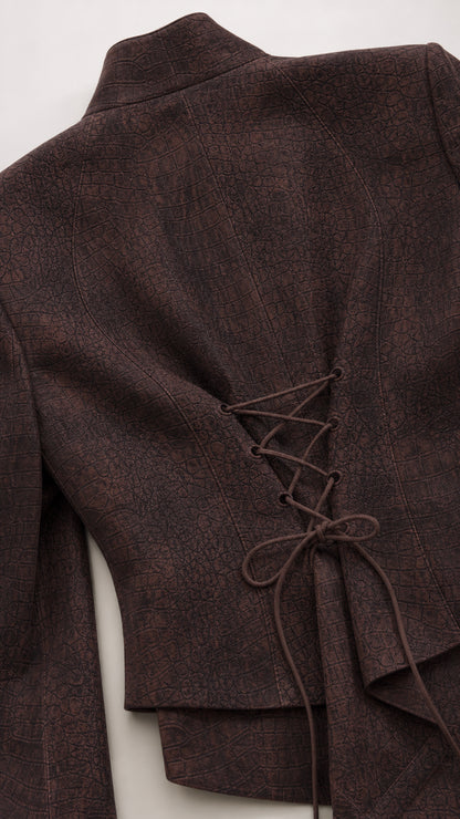 Close-up detail of textured woven fabric and corset lace-up tie on the blazer back