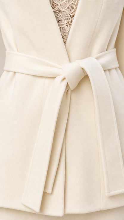 Close-up detail of the Cream blazer front waist tie belt and textured fabric