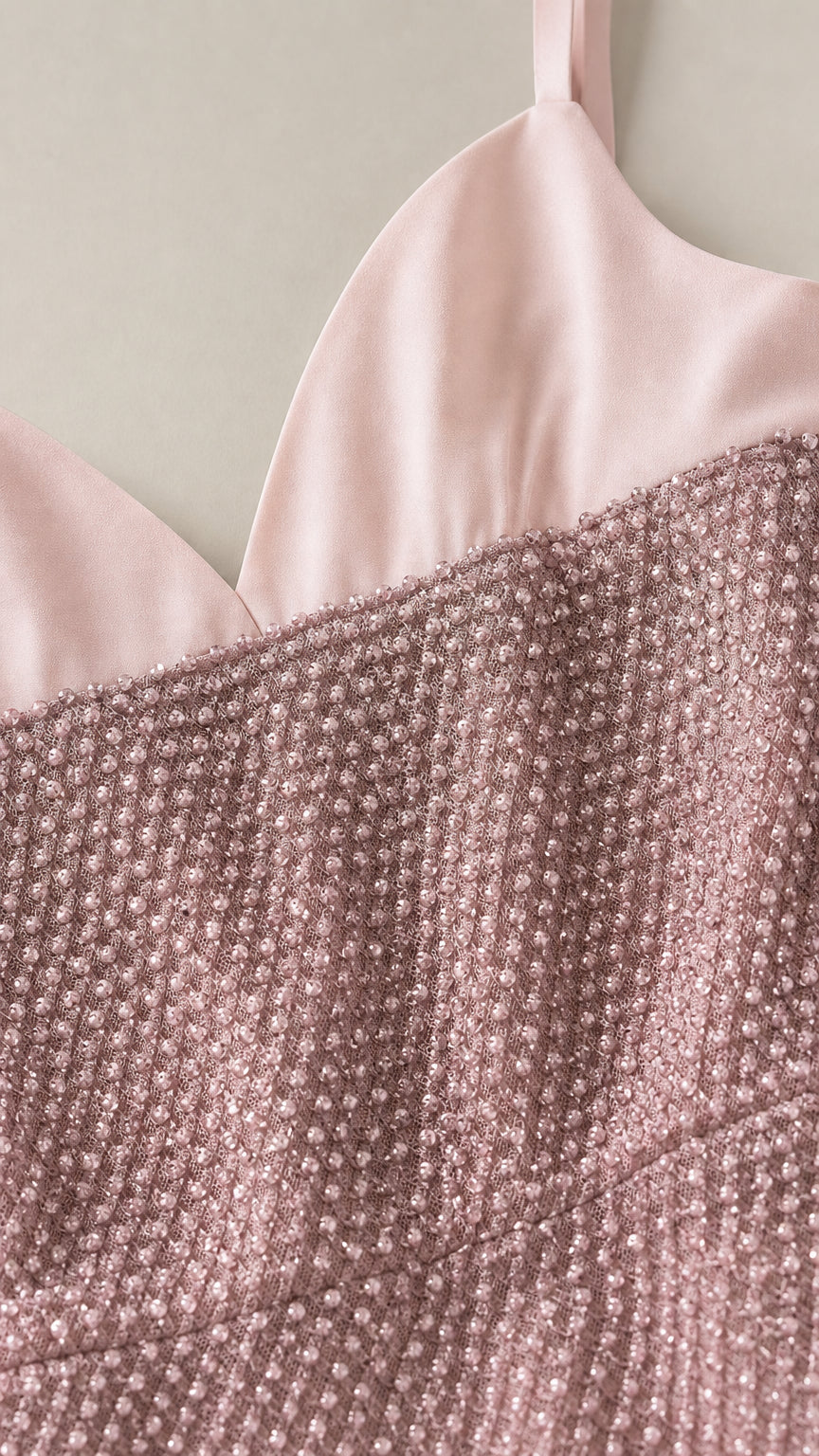Close-up detail of smooth satin-finish neckline and textured shimmer fabric in dusty rose