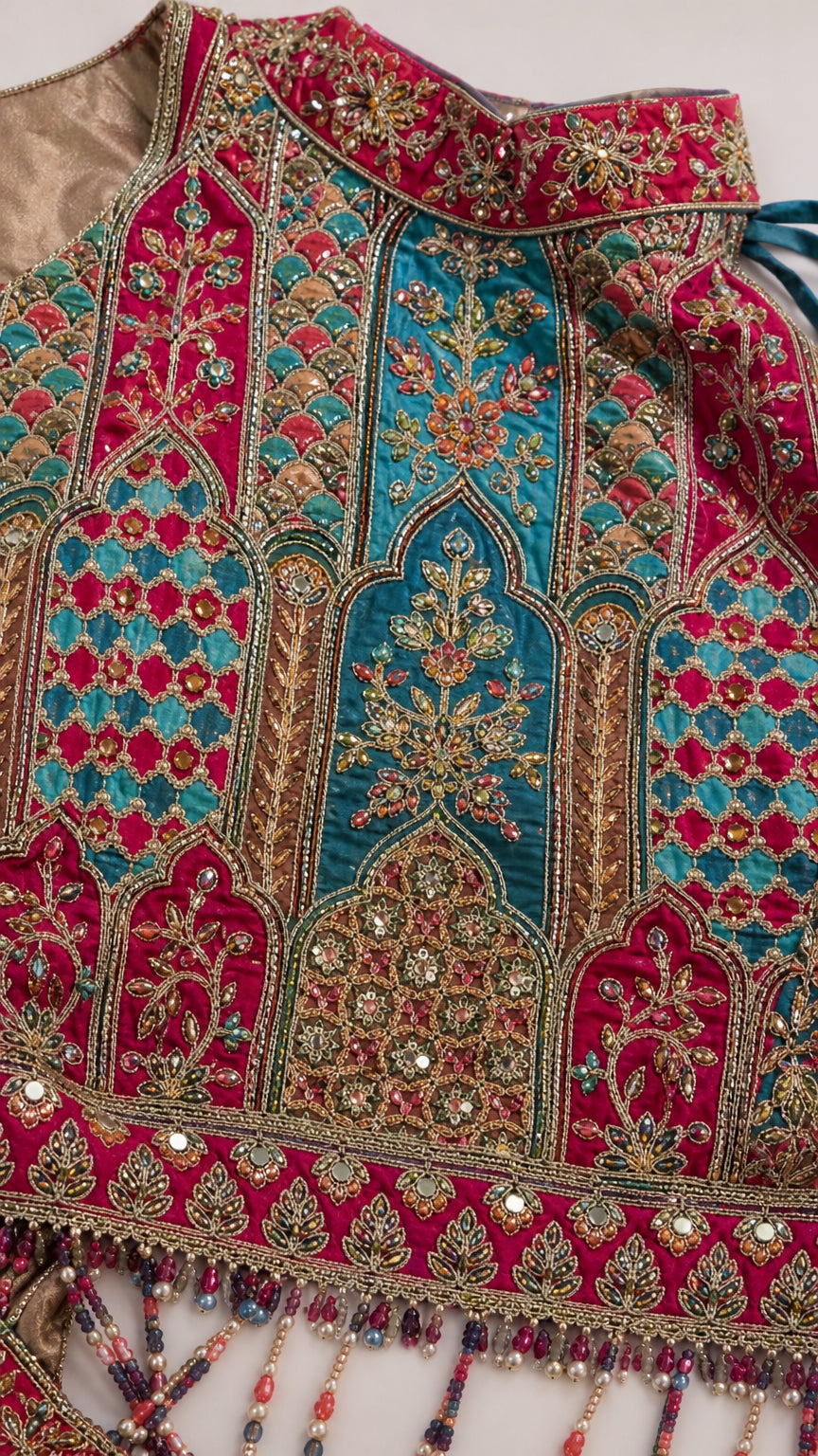 Close-up detail of intricate threadwork, bead embellishments, and hanging tassel fringe trim