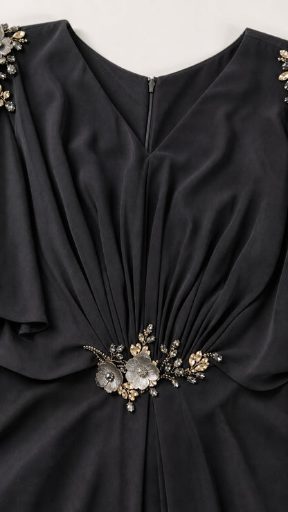 Close-up detail of black V-neck bodice with gathered pleats and crystal floral waist accent