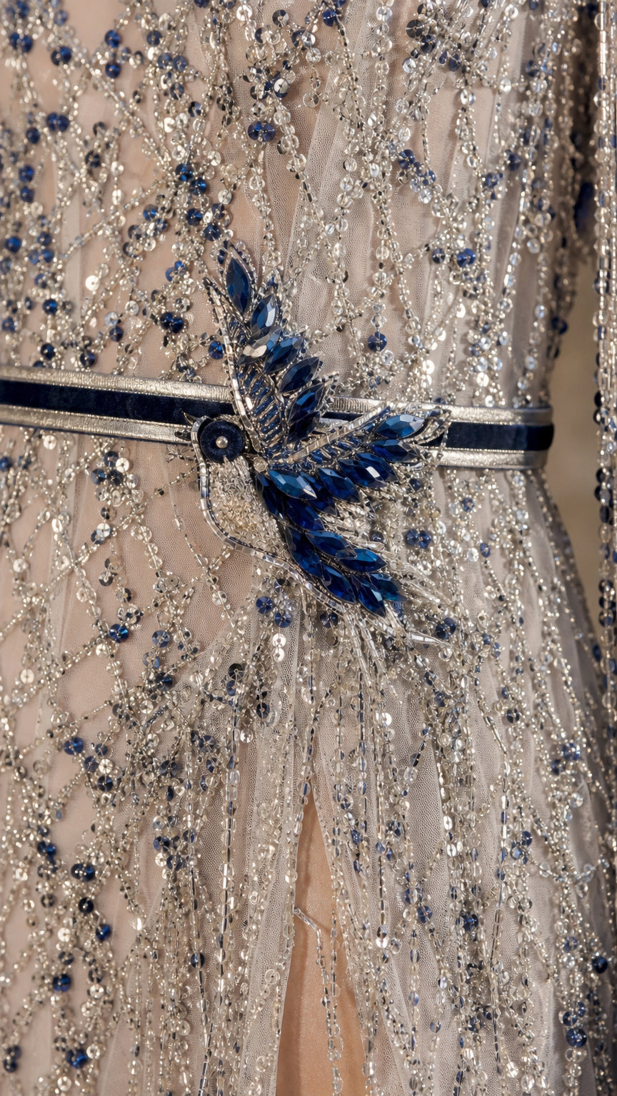 Close-up detail of intricate beadwork, sequin lines, and blue crystal embellishment on waistband
