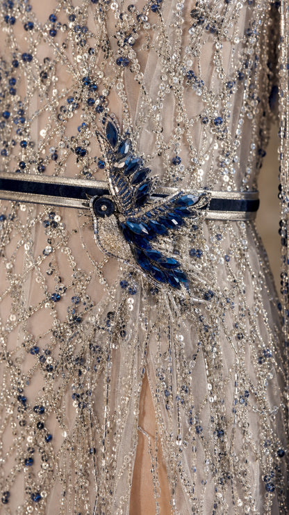 Close-up detail of intricate beadwork, sequin lines, and blue crystal embellishment on waistband