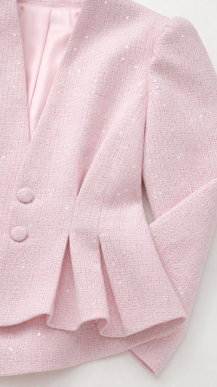 Close-up detail of textured blush pink tweed fabric and pleat detailing