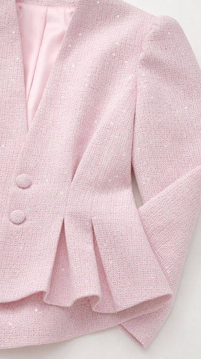 Close-up detail of textured blush pink tweed fabric and pleat detailing
