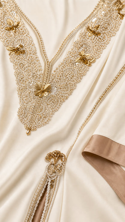 Close-up detail of ornate gold embroidery and beading on kaftan neckline