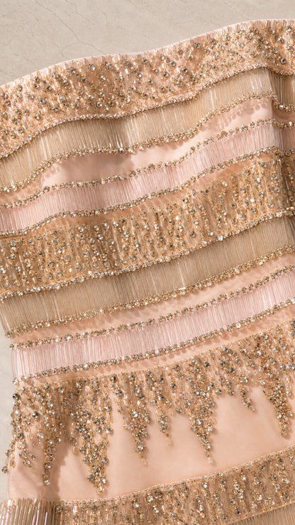 Close-up detail of blush pink beaded bodice with fringe trim and sequins