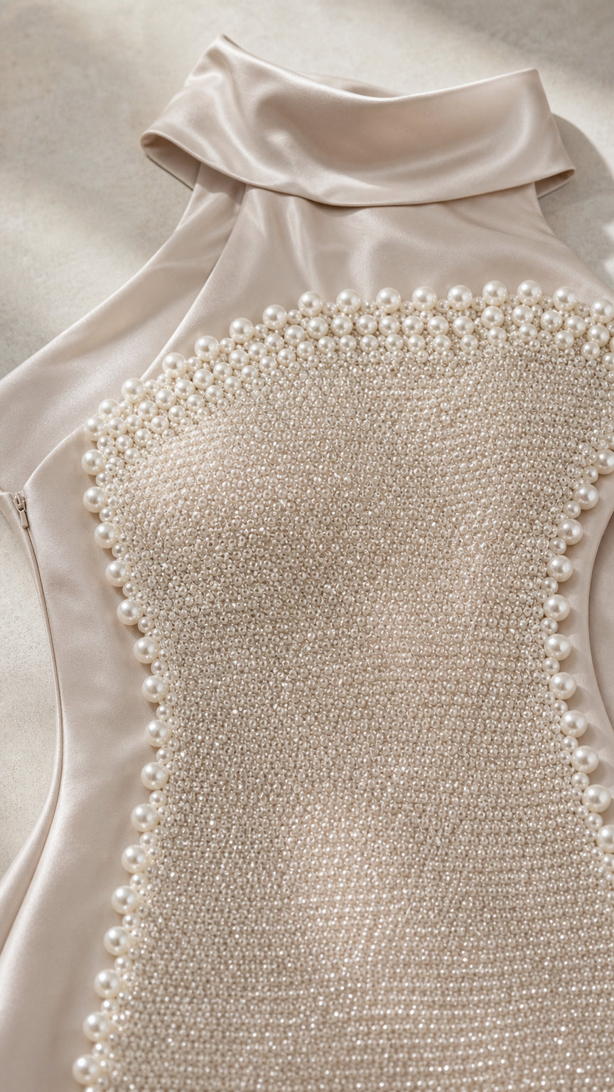 Close-up detail of pearl beadwork and high neckline on champagne satin gown