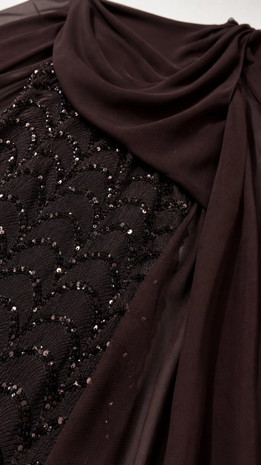 Close-up detail of shimmering scalloped sequin pattern and draped chiffon fabric in dark brown