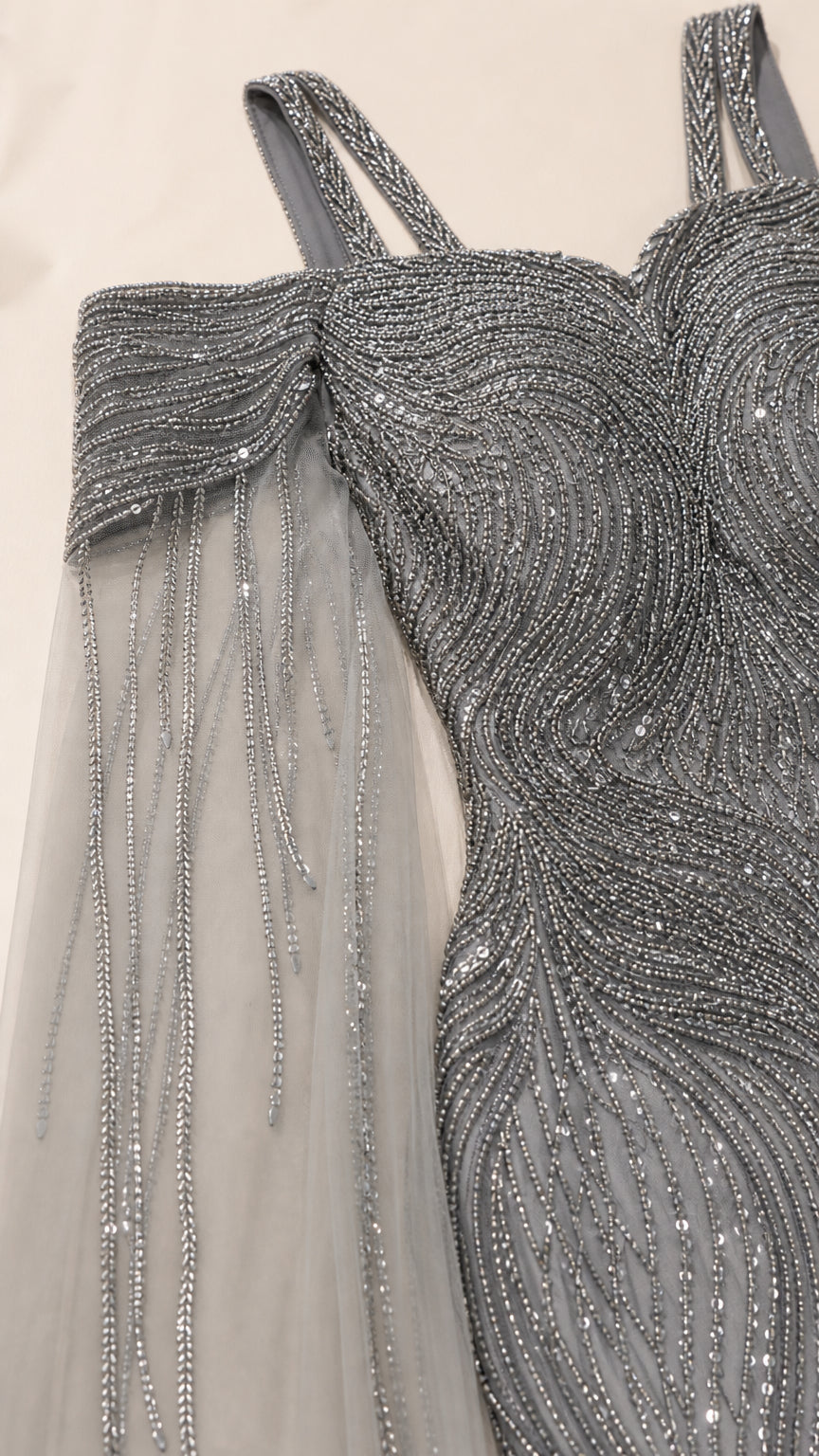 Close-up detail of silver sequin and bead embellishment on cold shoulder neckline