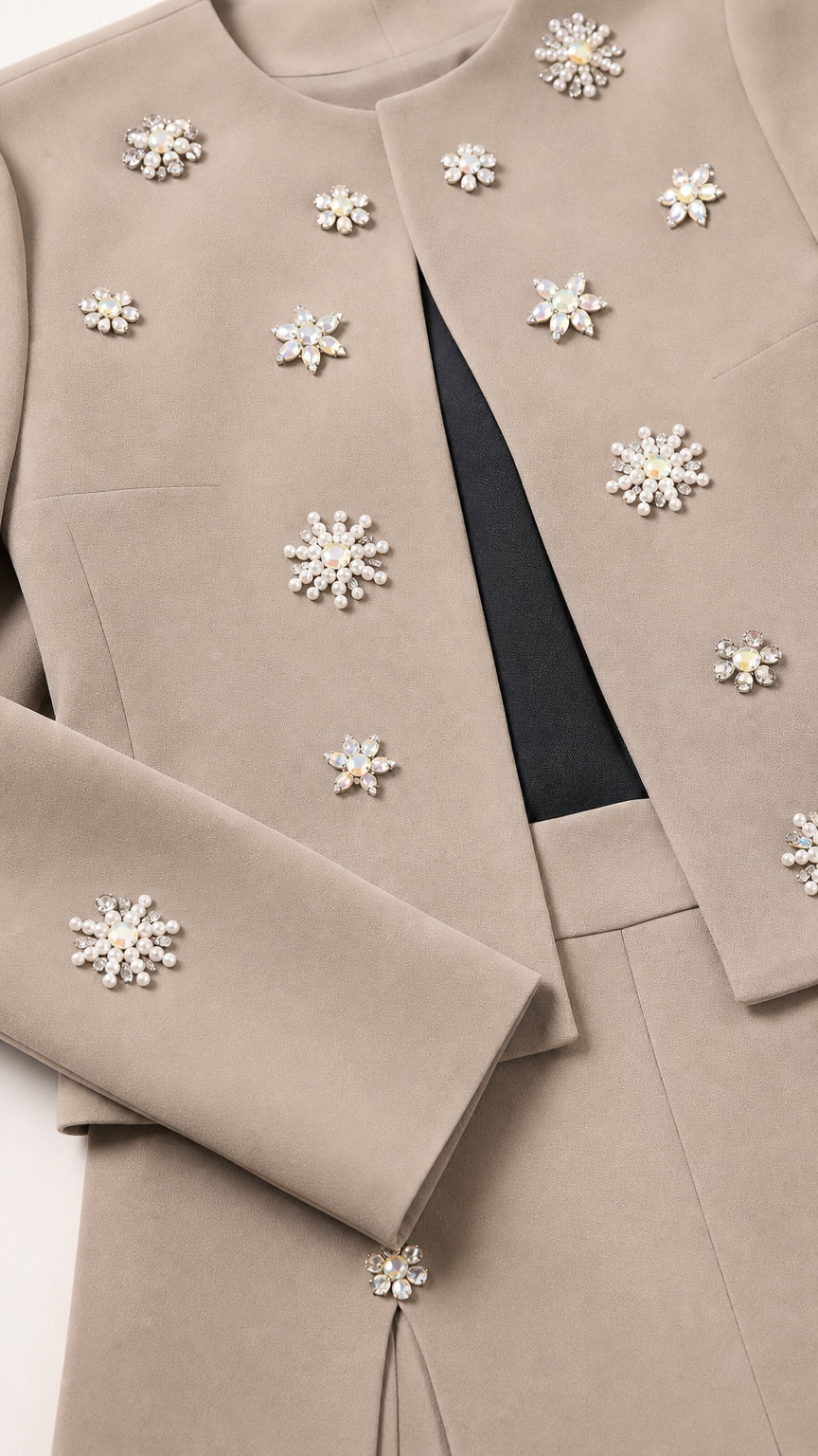 Close-up detail of crystal and pearl starburst embellishments on taupe fabric