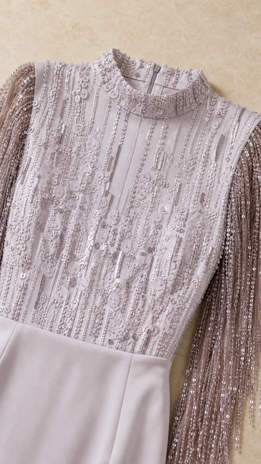 Close-up detail of embellished sequin bodice, mock collar, and fringe sleeve