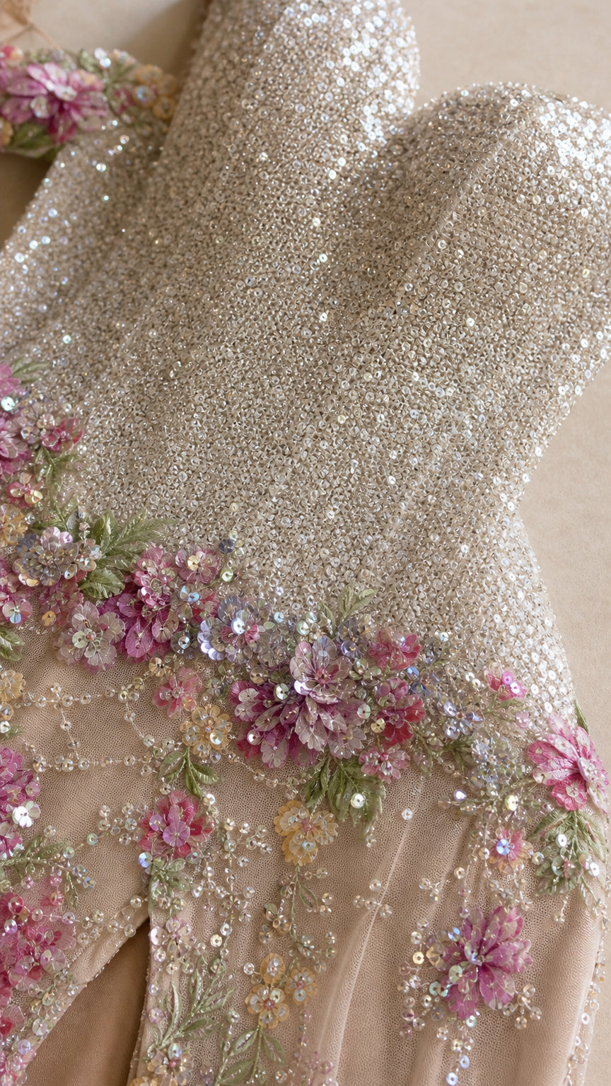 Close-up detail of sparkling sequin fabric and pastel floral embroidery appliques