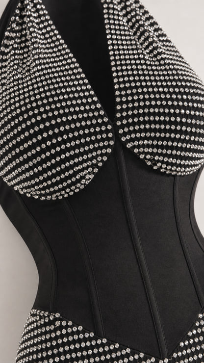 Close-up detail of rhinestone studs and structured corset boning on black dress
