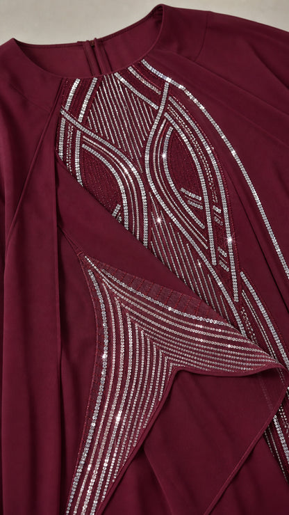 Close-up detail of silver rhinestone embellishments on burgundy kaftan neckline and sleeve