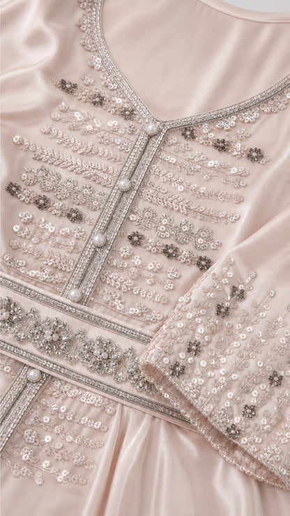 Close-up detail of sequined embroidery, decorative buttons, and satin fabric