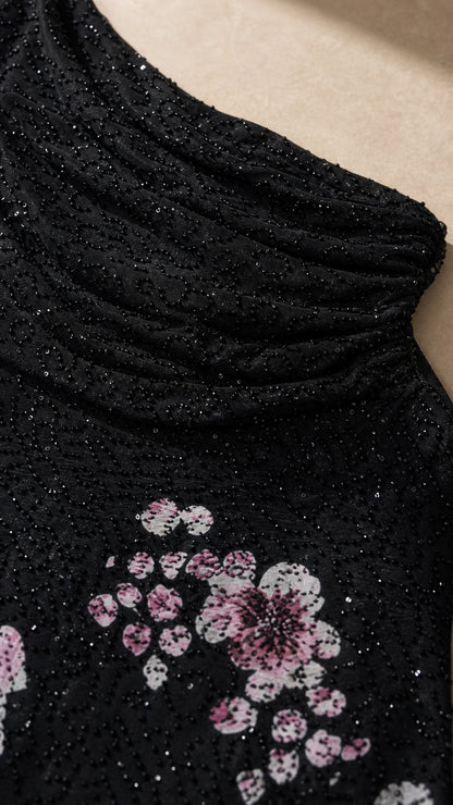 Close-up detail of textured shimmer fabric and floral print on black formal dress