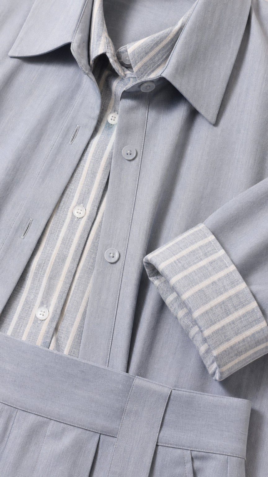 Close-up detail of the striped button-down collar, duster cuff, and pleated waistband