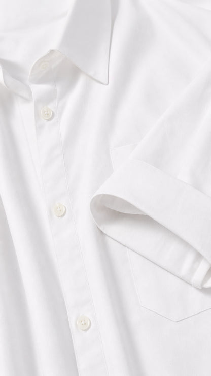 Close-up detail of collar, button placket, and pocket on white shirt dress