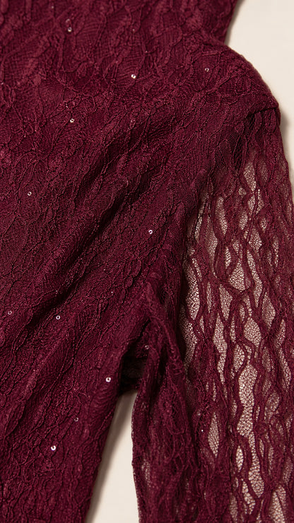 Close-up detail of burgundy sequin embroidered lace fabric and sheer sleeve