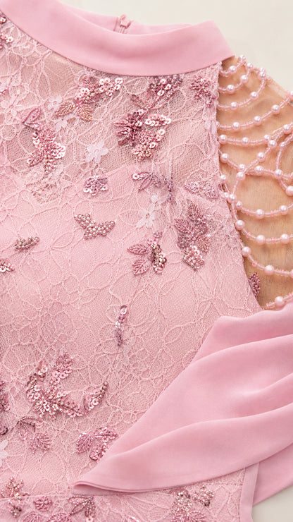 Close-up detail of pink floral sequin lace and draped pearl shoulder strands