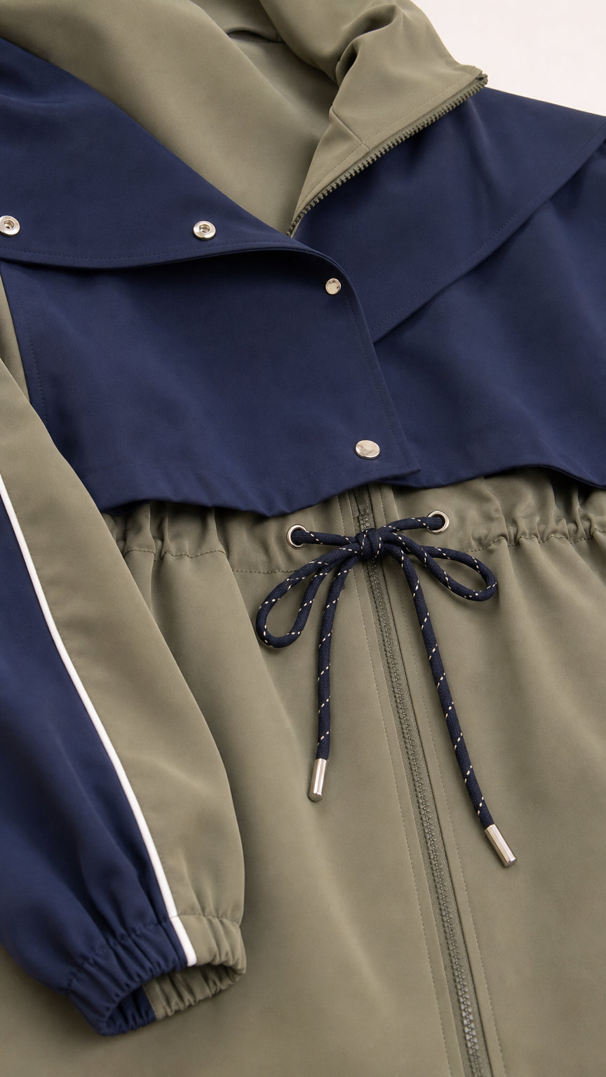 Close-up detail of navy windbreaker collar, zip front, and adjustable drawstring waist cord