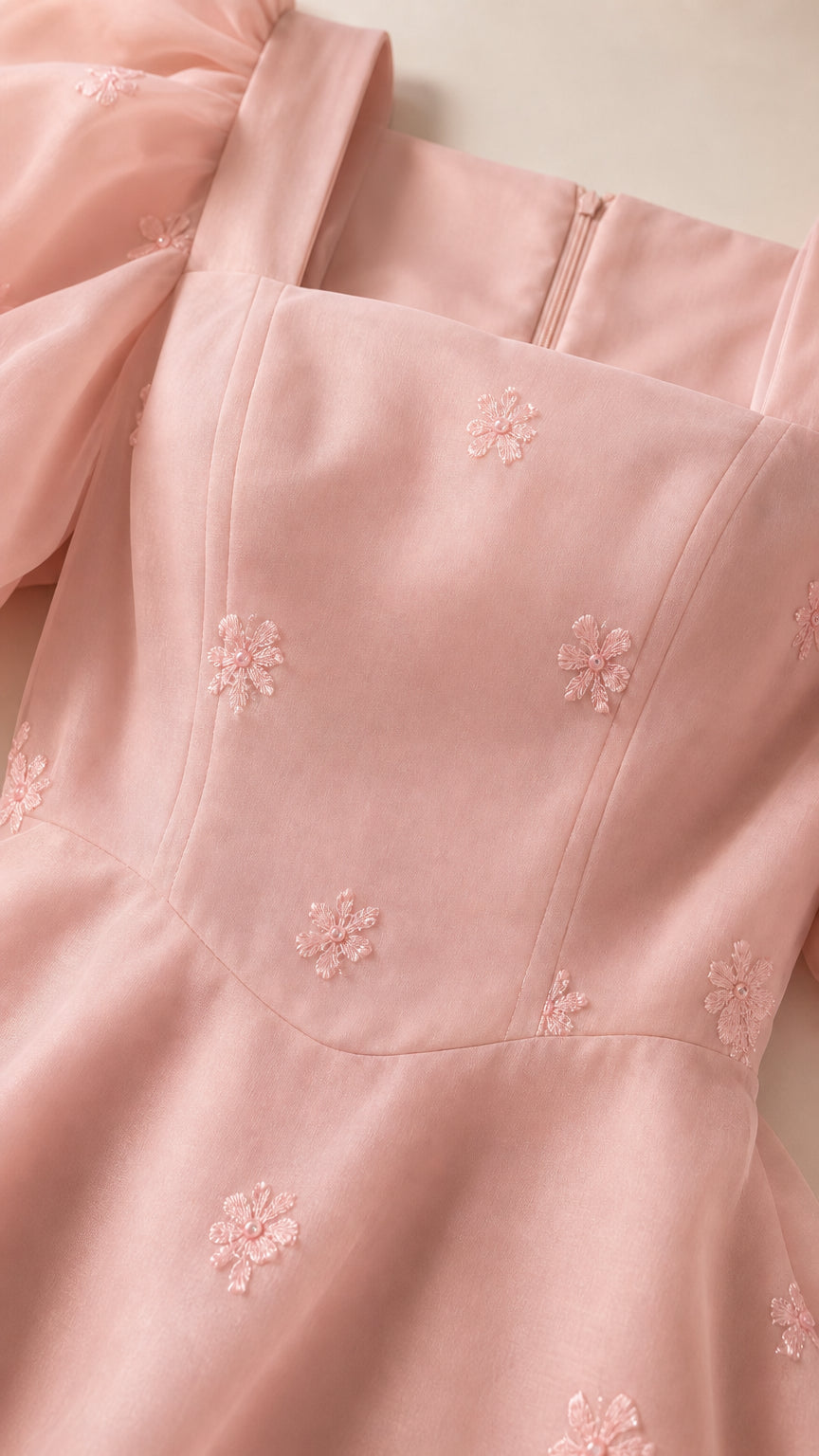 Close up of square neckline and floral embroidered fabric details