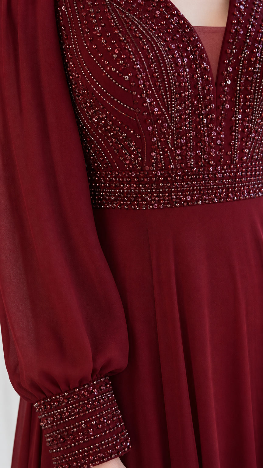 Close-up of burgundy beaded bodice and embellished cuff detailing