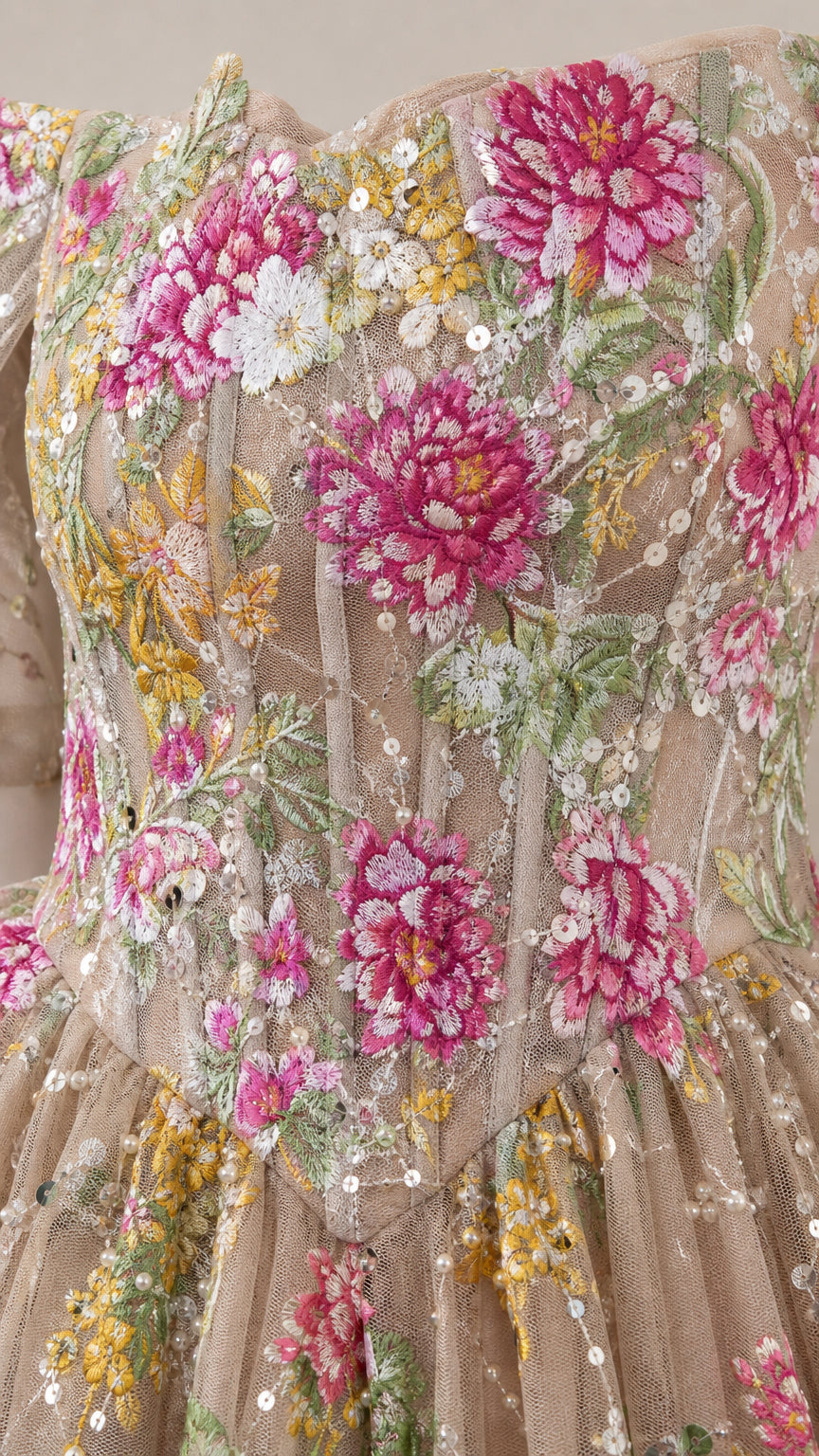 Close-up detail of bodice showing pink and yellow floral embroidery, boning, and sequin accents